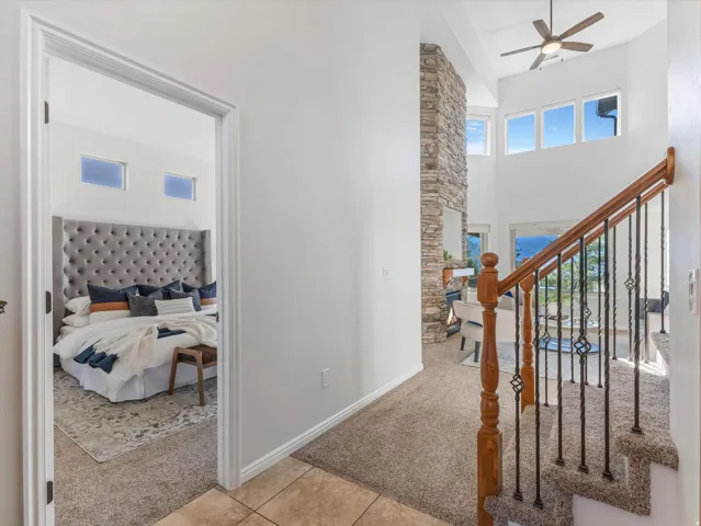 Two-story living area with high ceilings, ceiling fan, and large windows
