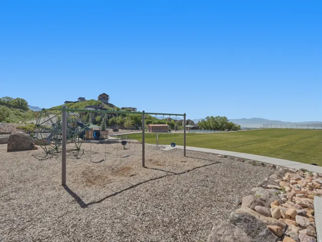 Expansive playground area with wood chip ground cover, swing set, and climbing structure