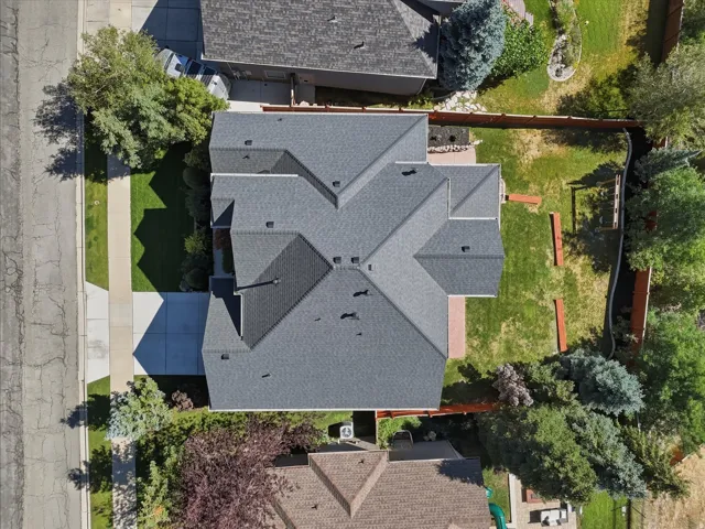 Multiple-pitch roof, expansive rear yard, mature perimeter landscaping, concrete driveway, and established front lawn