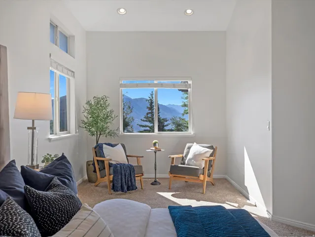 High ceilings featuring recessed lighting, a large window offering mountain scenery, and an additional transom window