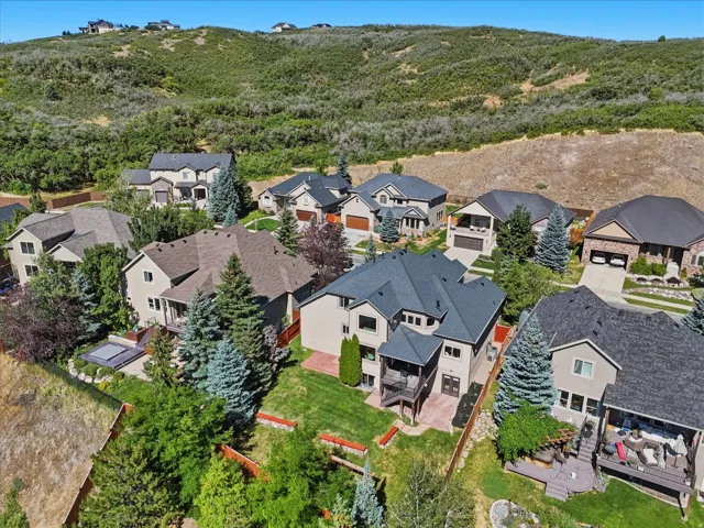 Expansive property with mature trees, a multi-level deck, and a recessed hot tub