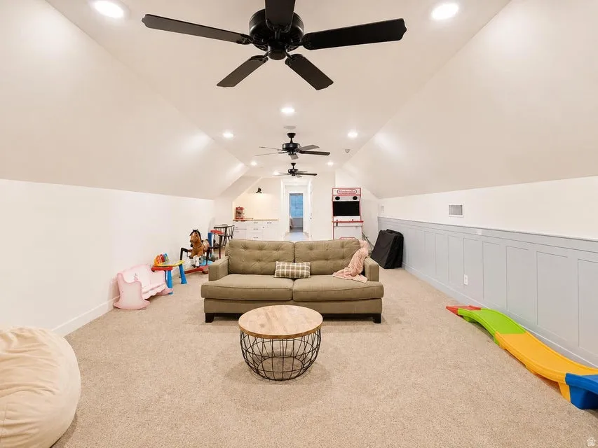 Sloped ceiling with recessed lighting and multiple ceiling fans
