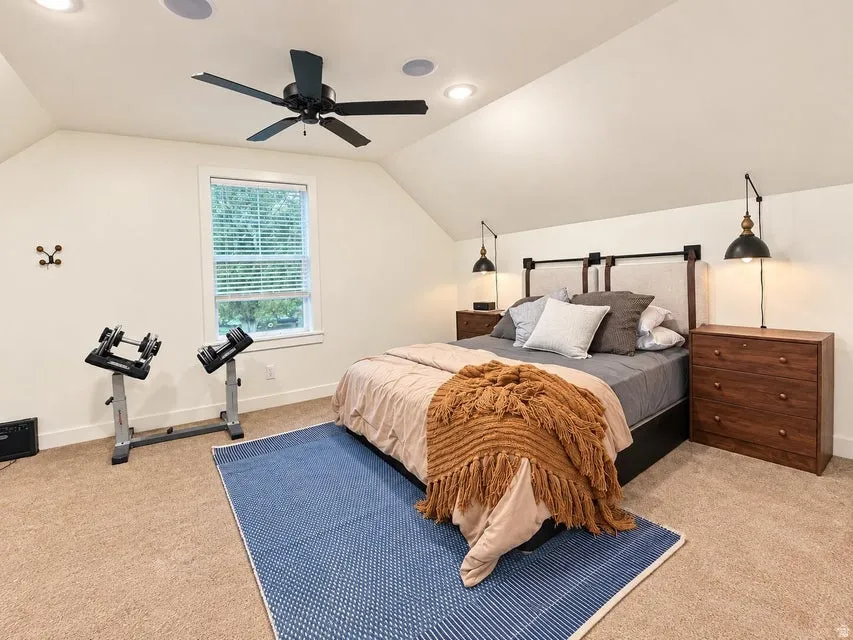 Carpeted room with a vaulted ceiling, recessed lighting, and a ceiling fan