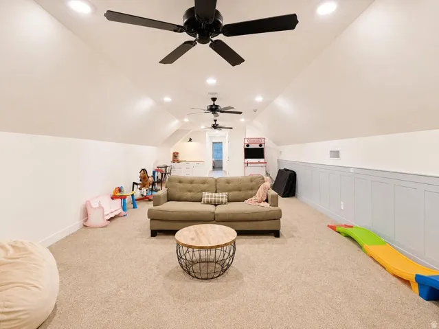 Sloped ceiling with recessed lighting and multiple ceiling fans