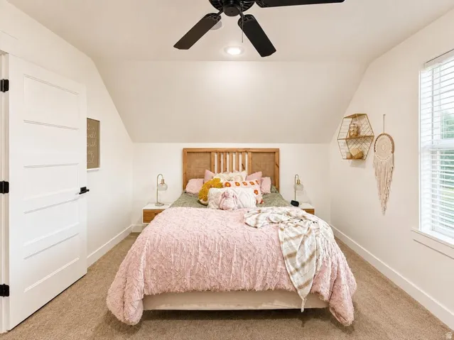 Carpeted flooring, vaulted ceiling, recessed lighting, ceiling fan, and a window with blinds