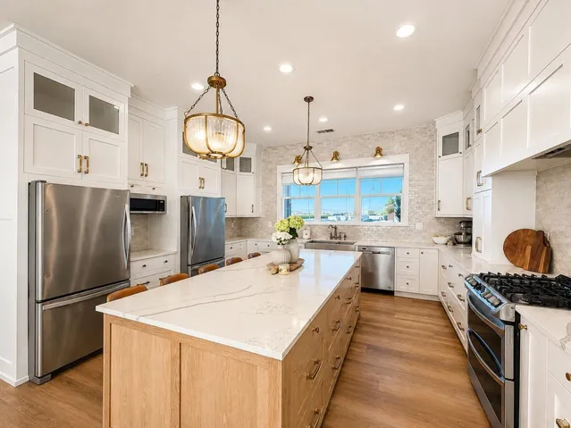 Kitchen with a large center island featuring a light-toned wood finish and a stone countertop