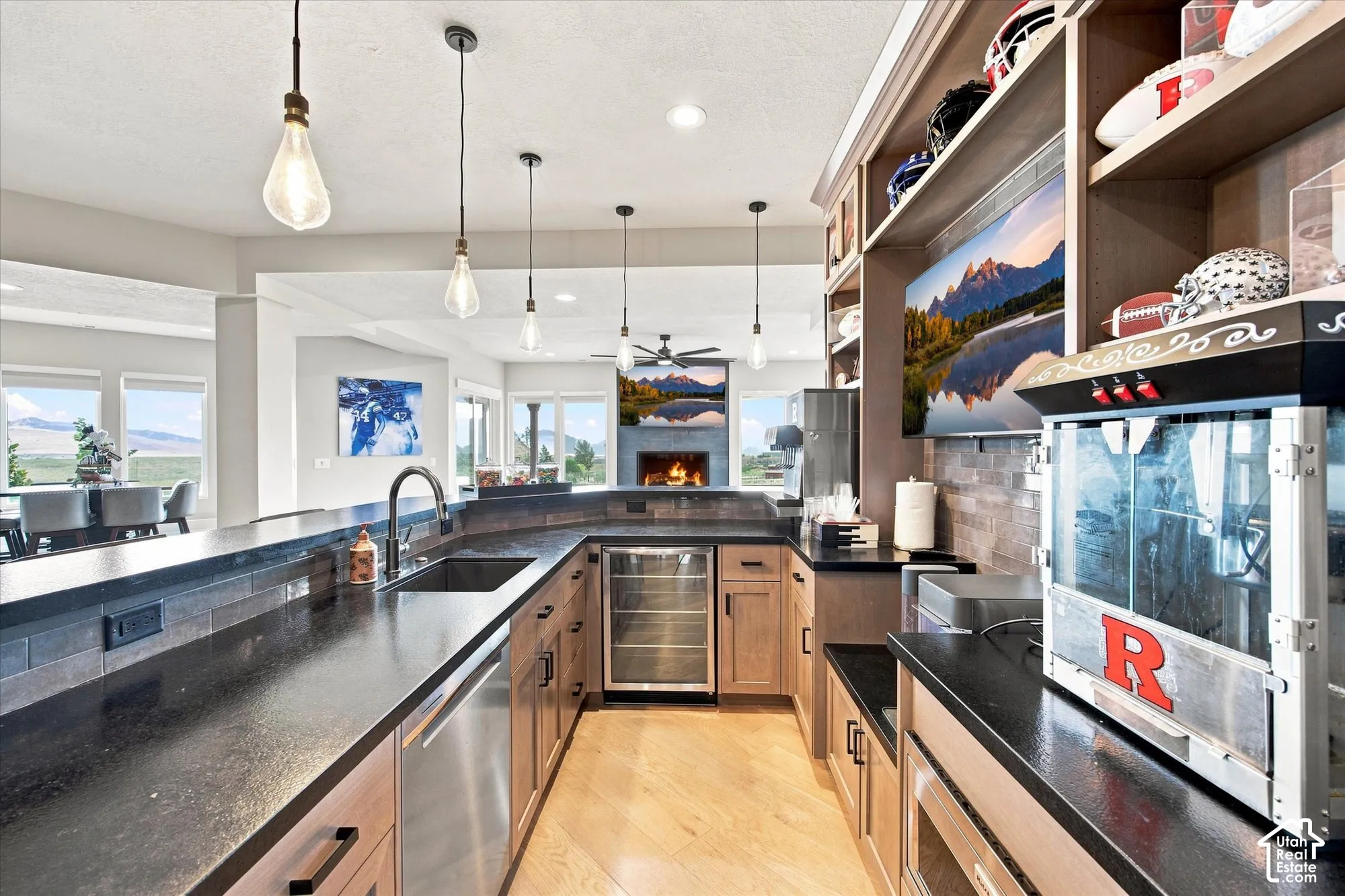 Curved peninsula with dark countertops, stainless steel sink, and integrated beverage cooler