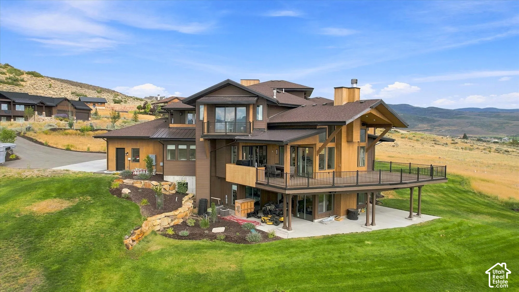 Multi-level exterior with extensive decking, wood siding, and a stone retaining wall