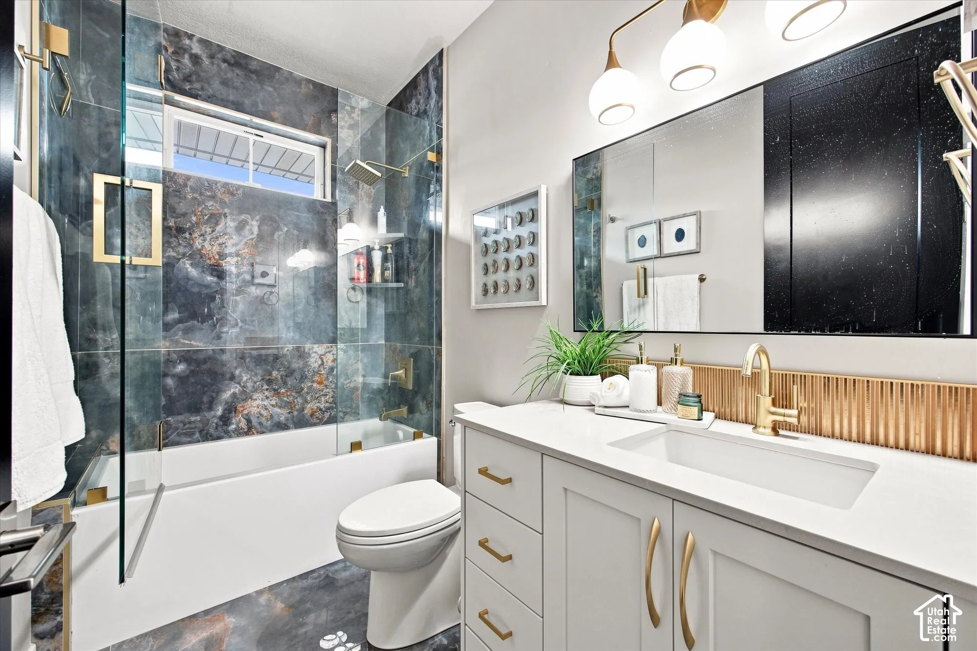 Bathroom featuring a white vanity with gold hardware, a rectangular undermount sink, and a gold-toned faucet