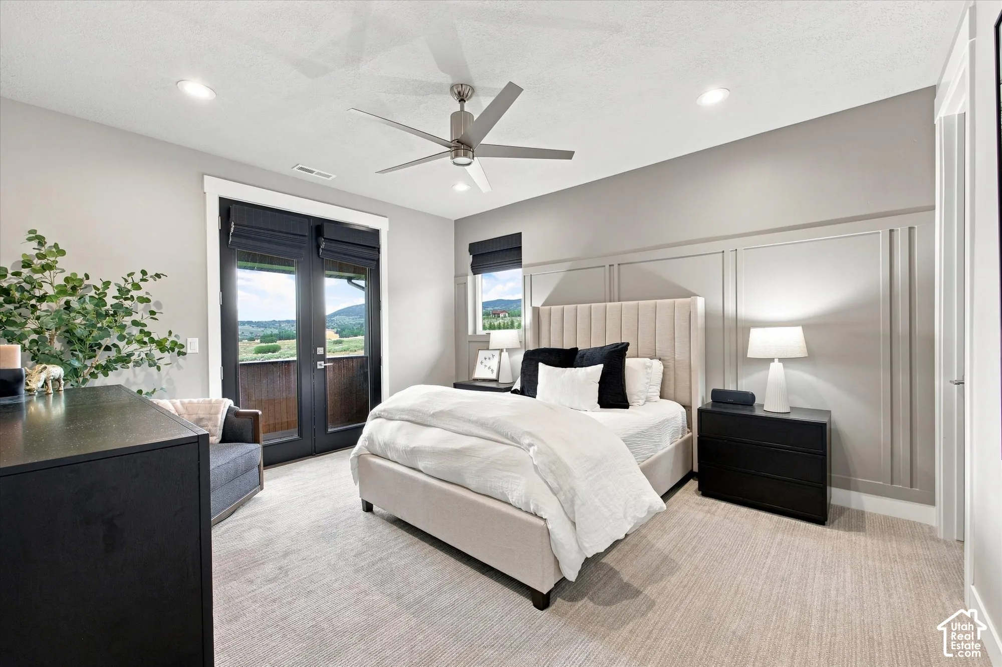 Recessed lighting, ceiling fan, accent wall with panel molding, French doors with exterior access, and neutral-toned carpeting