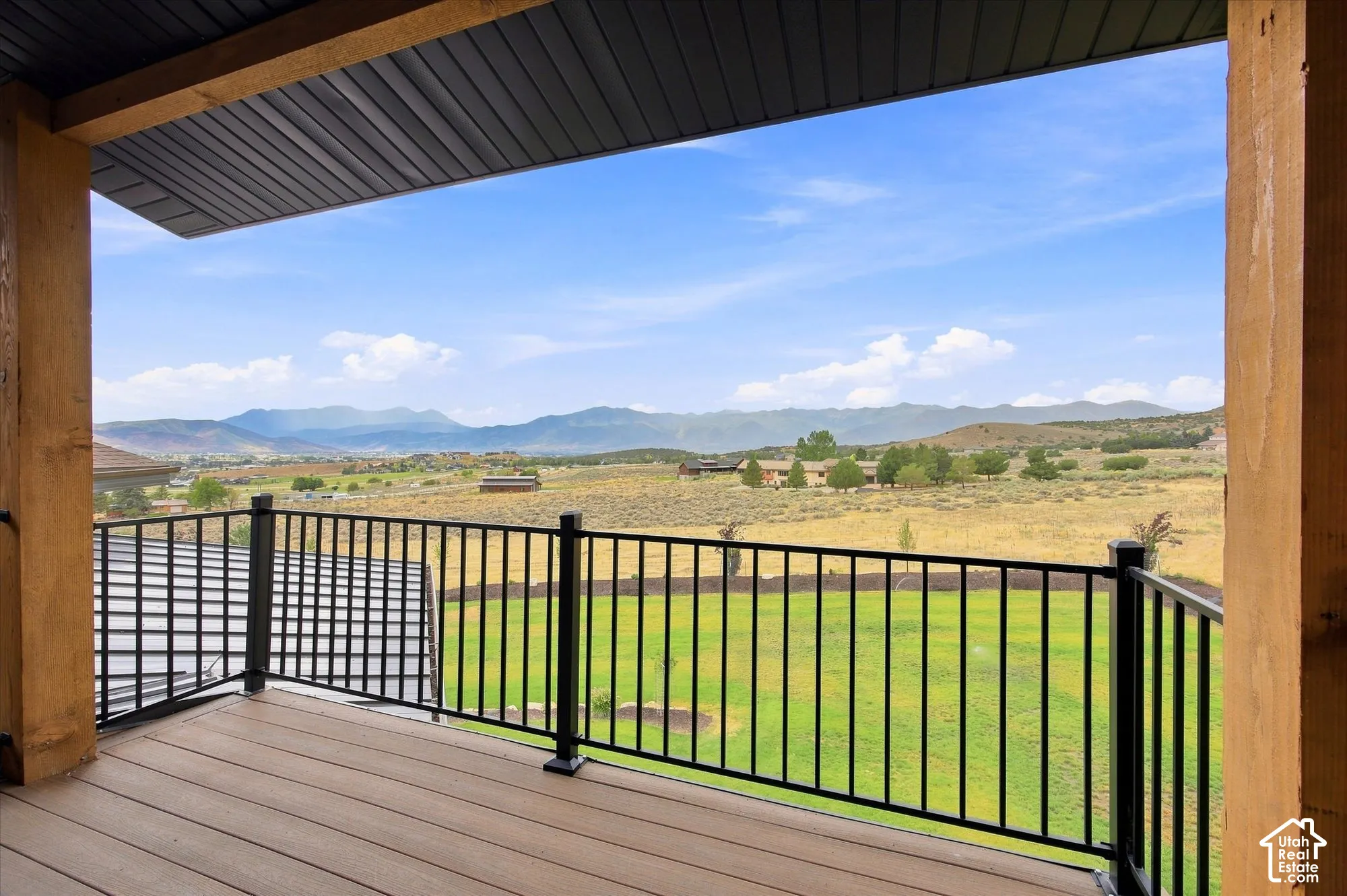 Primary Suite's covered balcony  with wood-finish decking and black metal railings