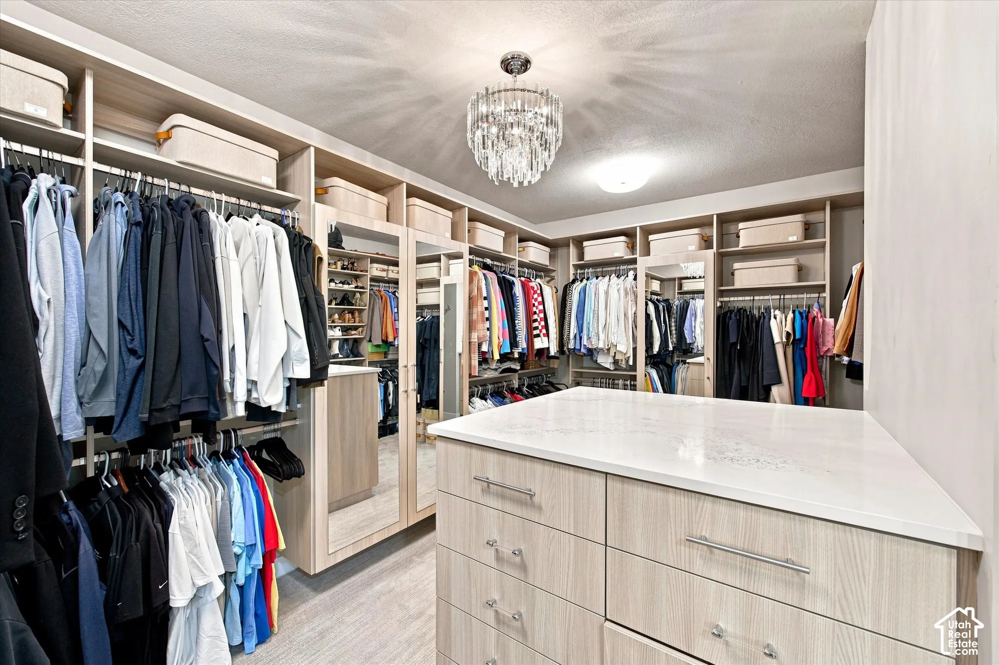 Primary Full walk-in custom closet system with extensive built-in shelving, hanging rods, and integrated drawers
