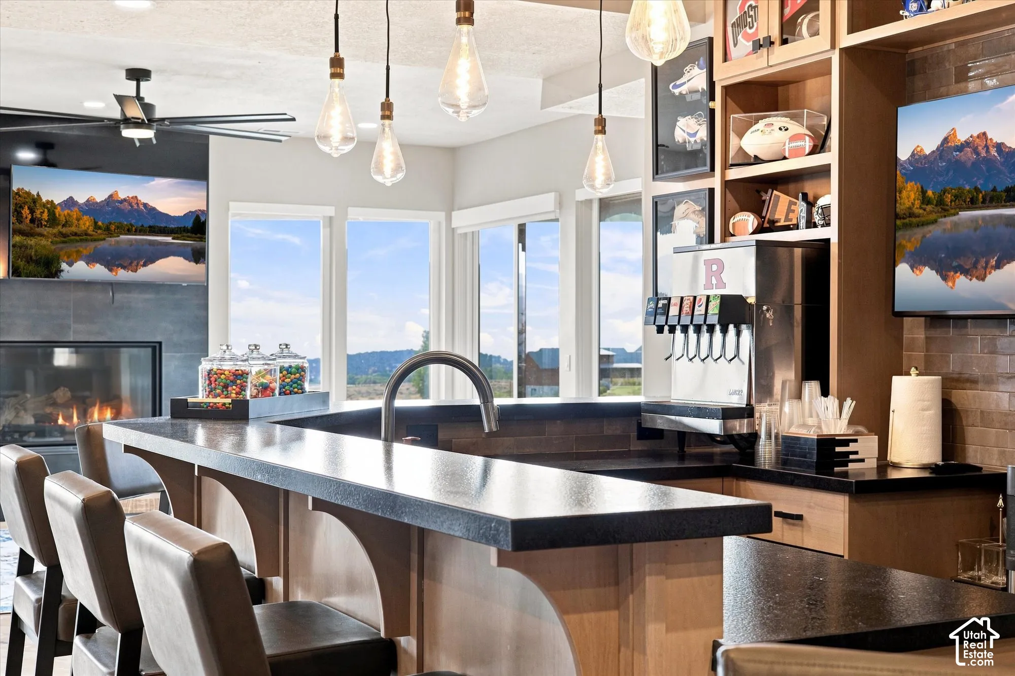 Built-in bar area featuring stone-finish countertops, an integrated sink, and modern pendant lighting