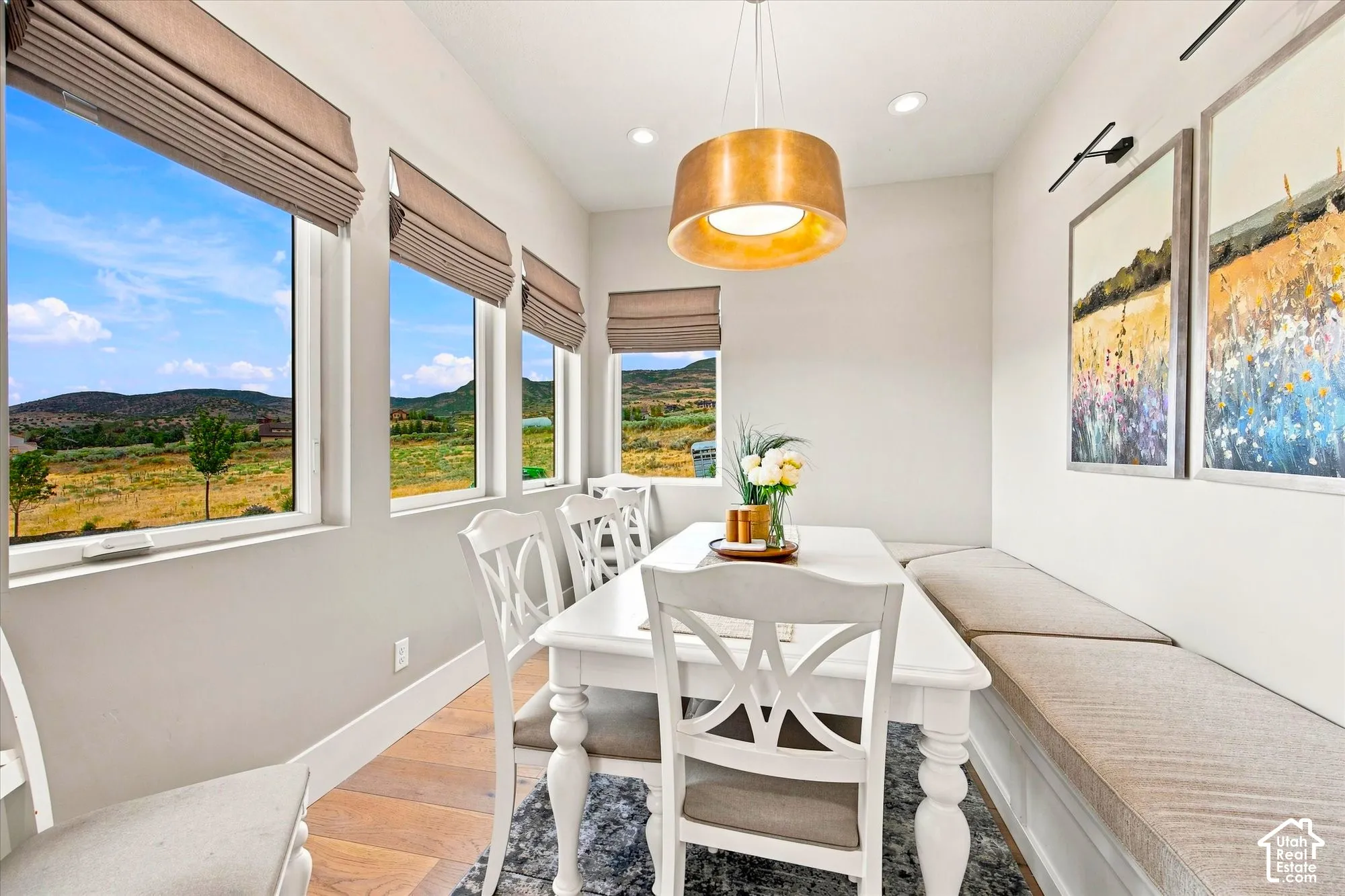 Multiple windows with roller shades, recessed lighting, and a drum pendant light