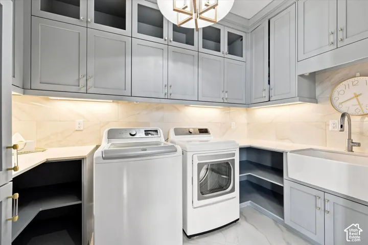 Upper and lower cabinetry with glass-front accents, undermount lighting, durable countertops, and a built-in farmhouse sink