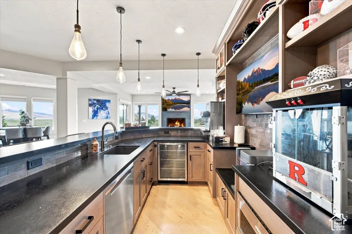 Curved peninsula with dark countertops, stainless steel sink, and integrated beverage cooler