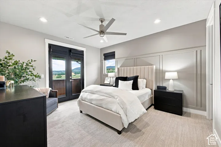 Recessed lighting, ceiling fan, accent wall with panel molding, French doors with exterior access, and neutral-toned carpeting