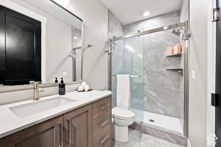 Vanity with wood-finish cabinetry, white countertop, and rectangular undermount sink