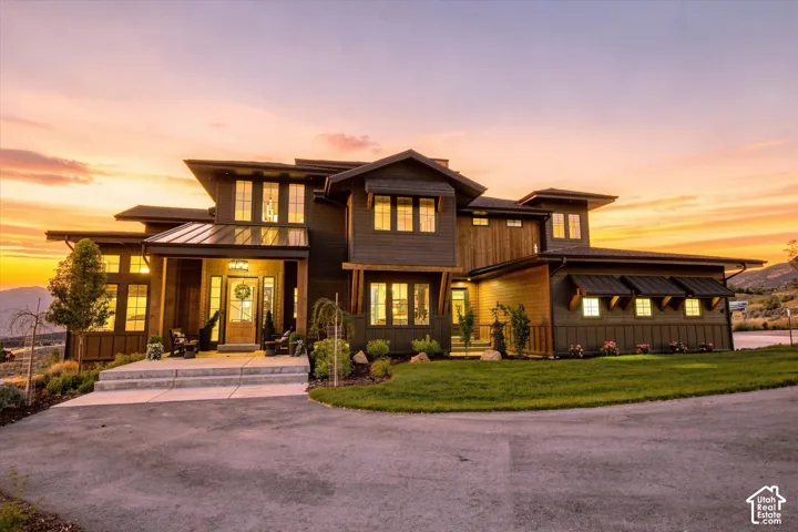 Modern exterior featuring multiple rooflines, a covered entry with columns, extensive fenestration, and a concrete driveway