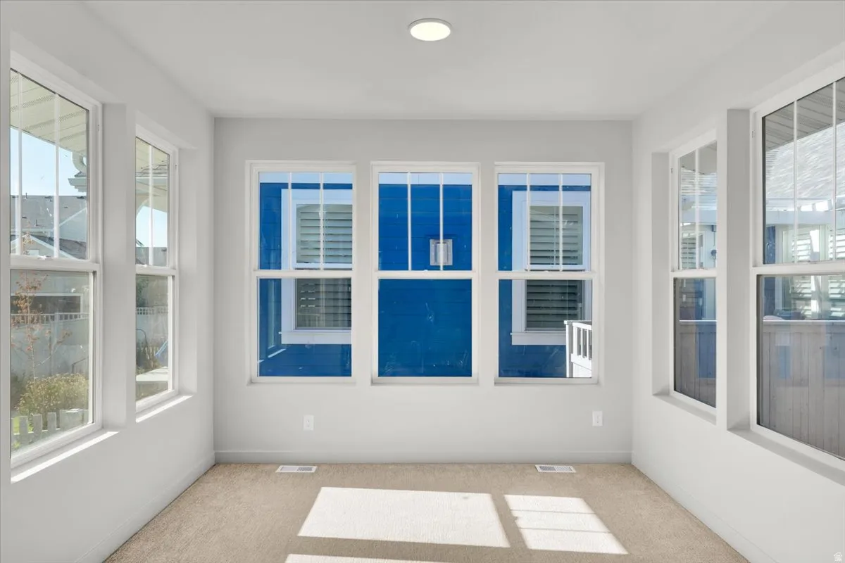 Recessed ceiling light, neutral wall paint, white window trim, carpeted flooring, multiple windows