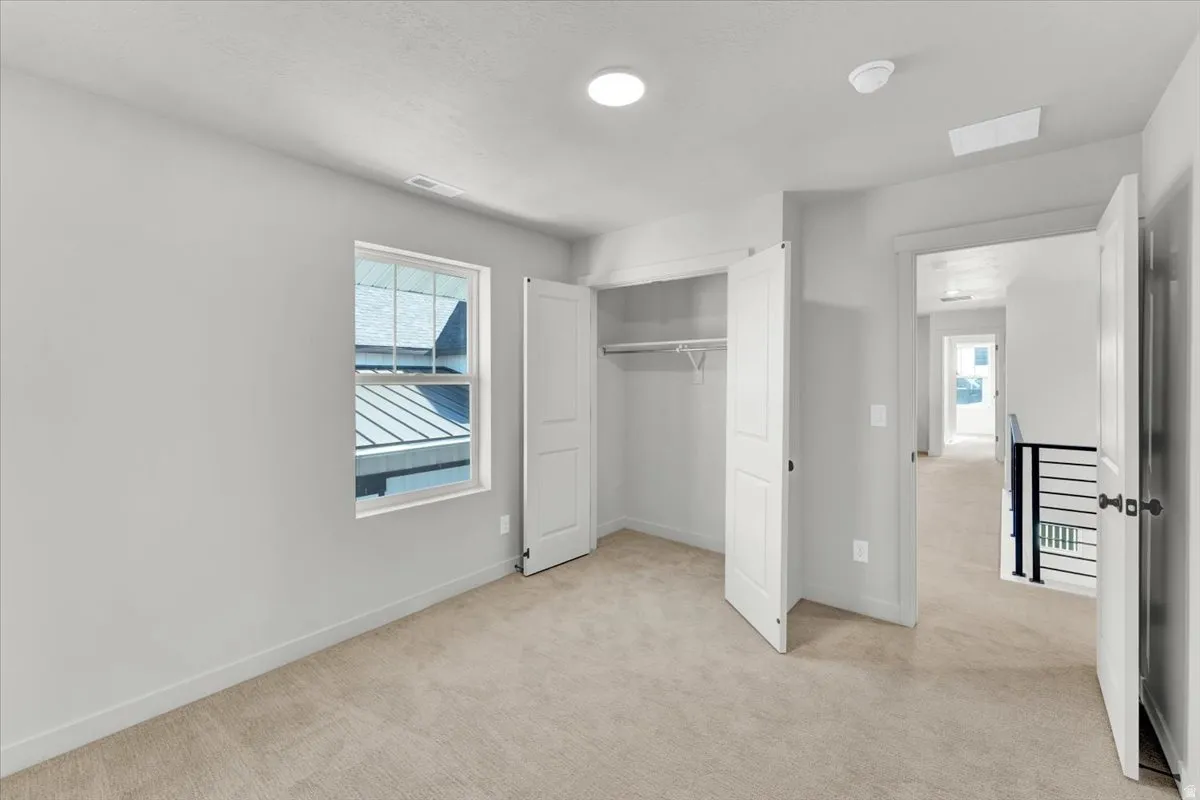 Wall-to-wall carpeting, double-door closet, recessed lighting, and a single window with a white frame