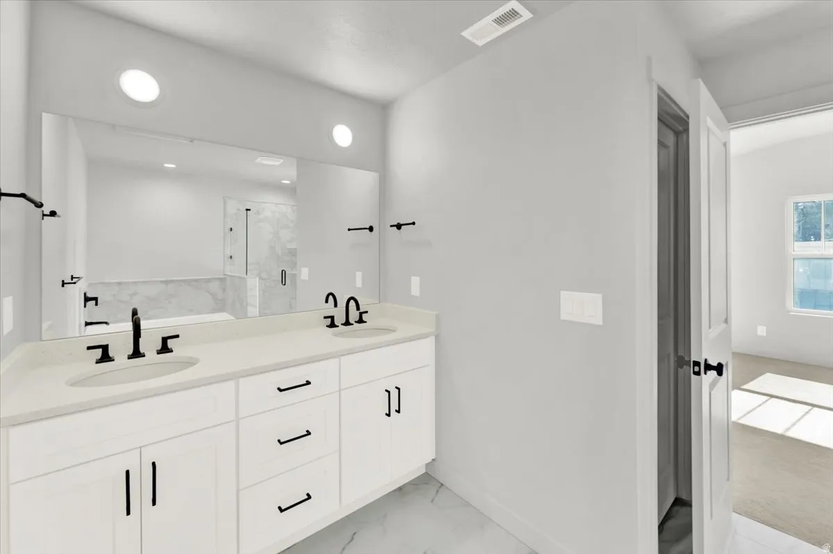 Dual sink vanity with light-toned countertops and matte black fixtures