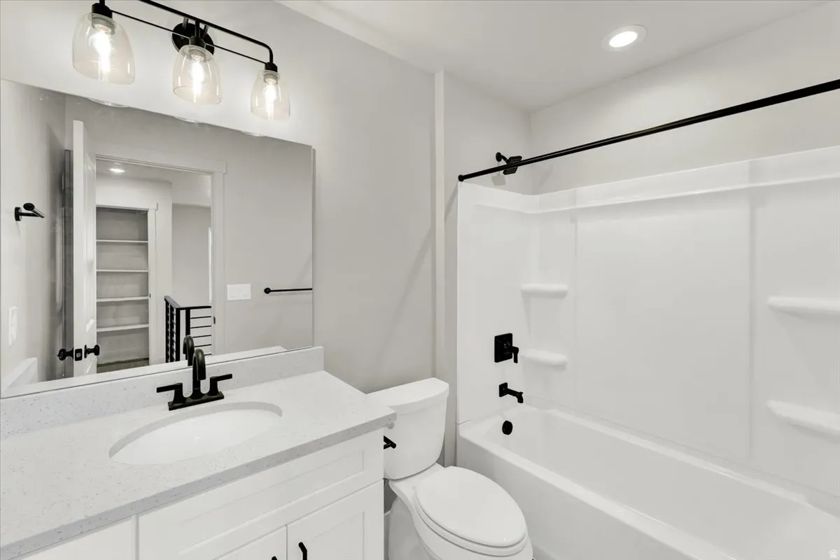 White vanity with shaker-style cabinetry, a built-in sink, and a light-toned countertop