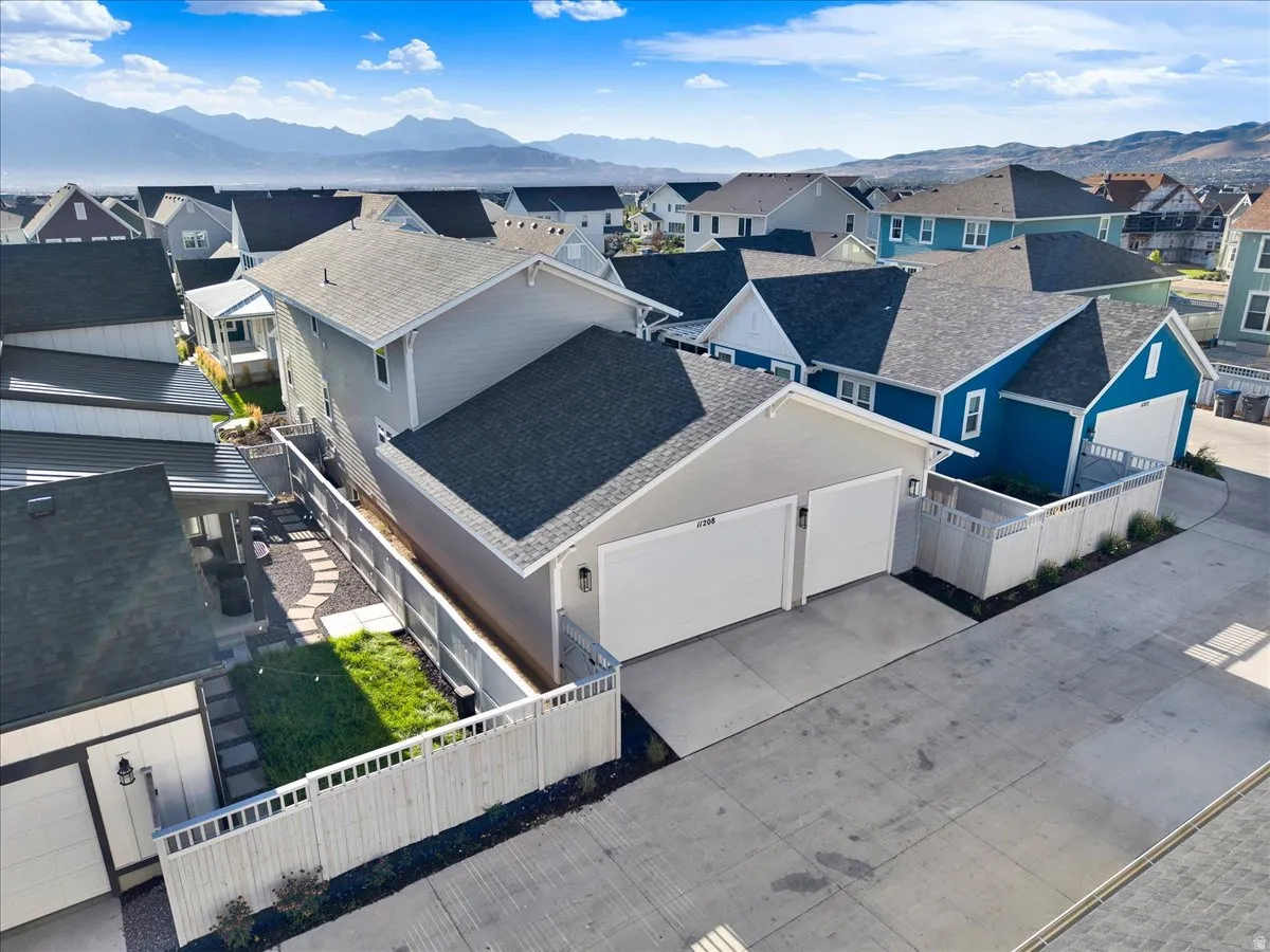 Two-car garage, private backyard with paved patio, manicured lawn, and surrounding privacy fencing