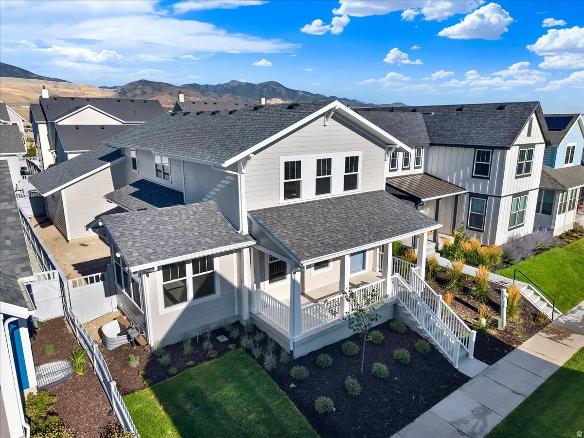Two-story residence with a covered front porch featuring white railings