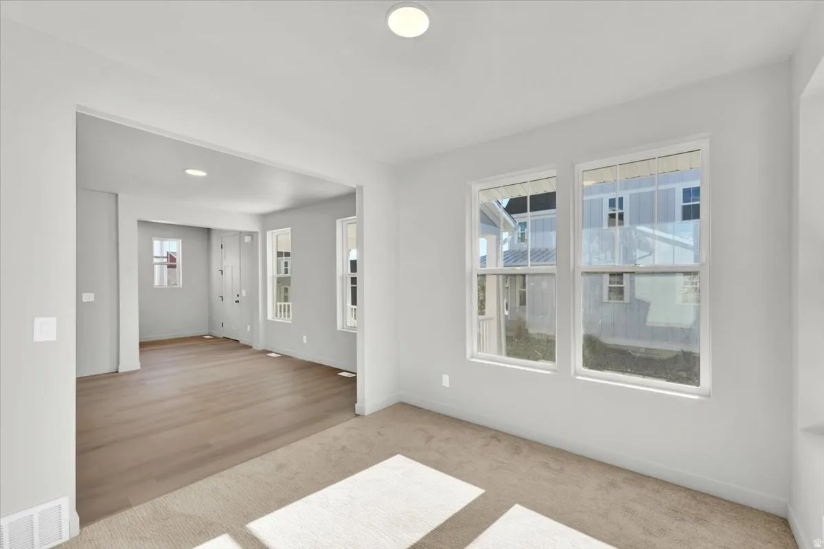 Recessed lighting, light gray wall finishes, dual pane windows, carpet flooring, and wood-finish flooring