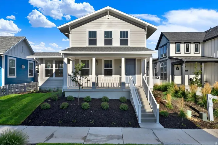 Two-story residence featuring light gray siding with white trim, a covered front porch, and a dark gray shingle roof