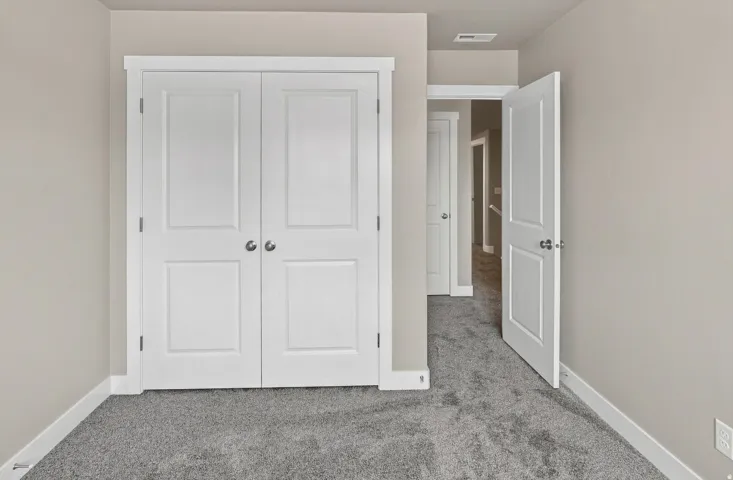 Neutral-toned walls complement the gray carpeting