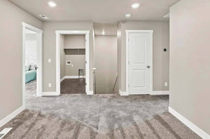 Plush carpet flooring, recessed lighting, neutral wall paint, white trim, and a built-in laundry closet with shelving
