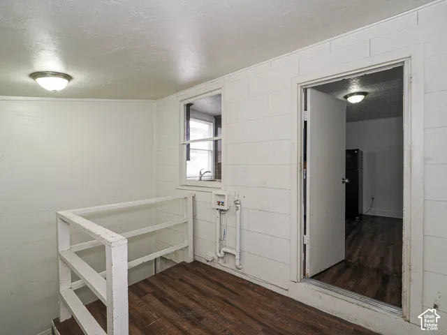 Wood-finish flooring, white paneled walls, flush-mount lighting, single-hung window, and utility hookups