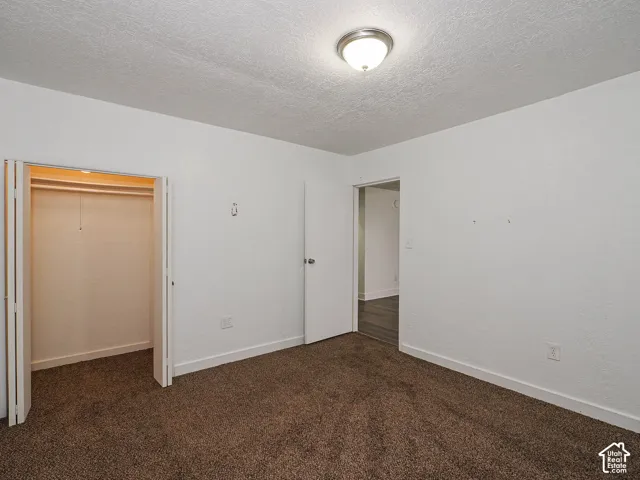 Room featuring neutral wall tones, carpeted flooring, a flush-mount ceiling light fixture, and a built-in closet with bifold doors