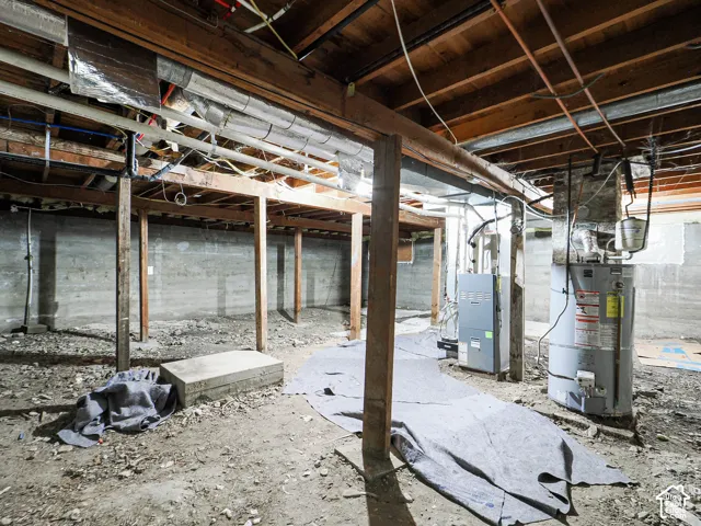 Unfinished basement featuring exposed joists, concrete foundation walls, a utility furnace, and a water heater