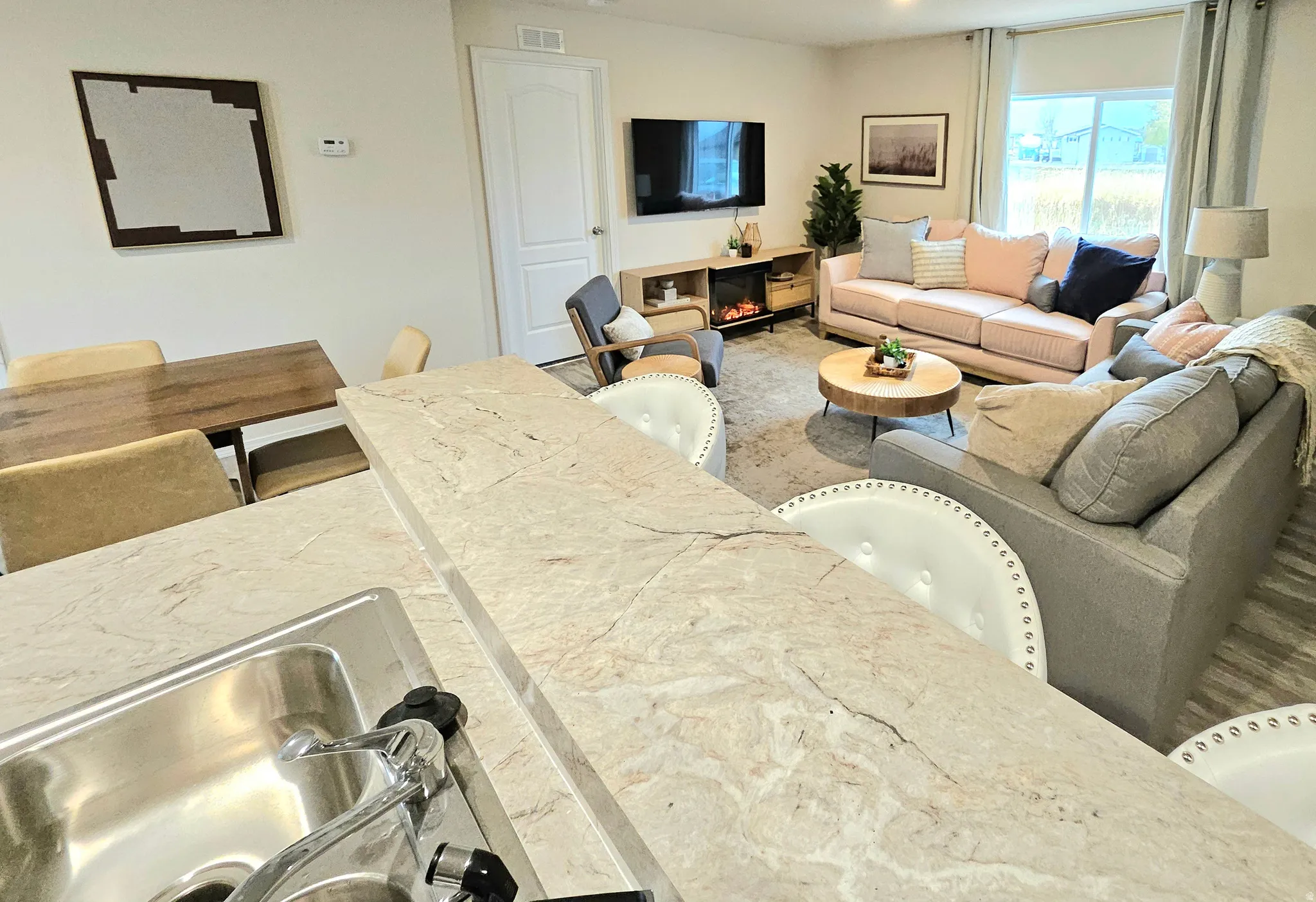 Open-concept living area with a built-in electric fireplace, recessed lighting, and large windows