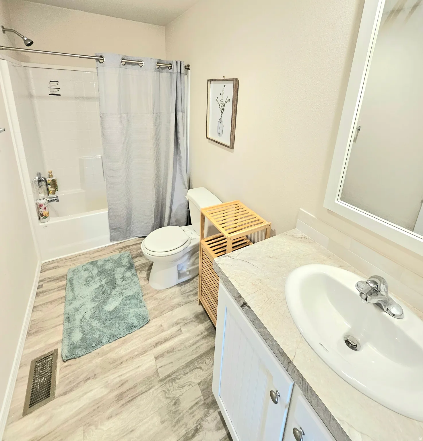 Bathroom featuring a white vanity with a built-in sink, chrome fixtures, and a white framed mirror