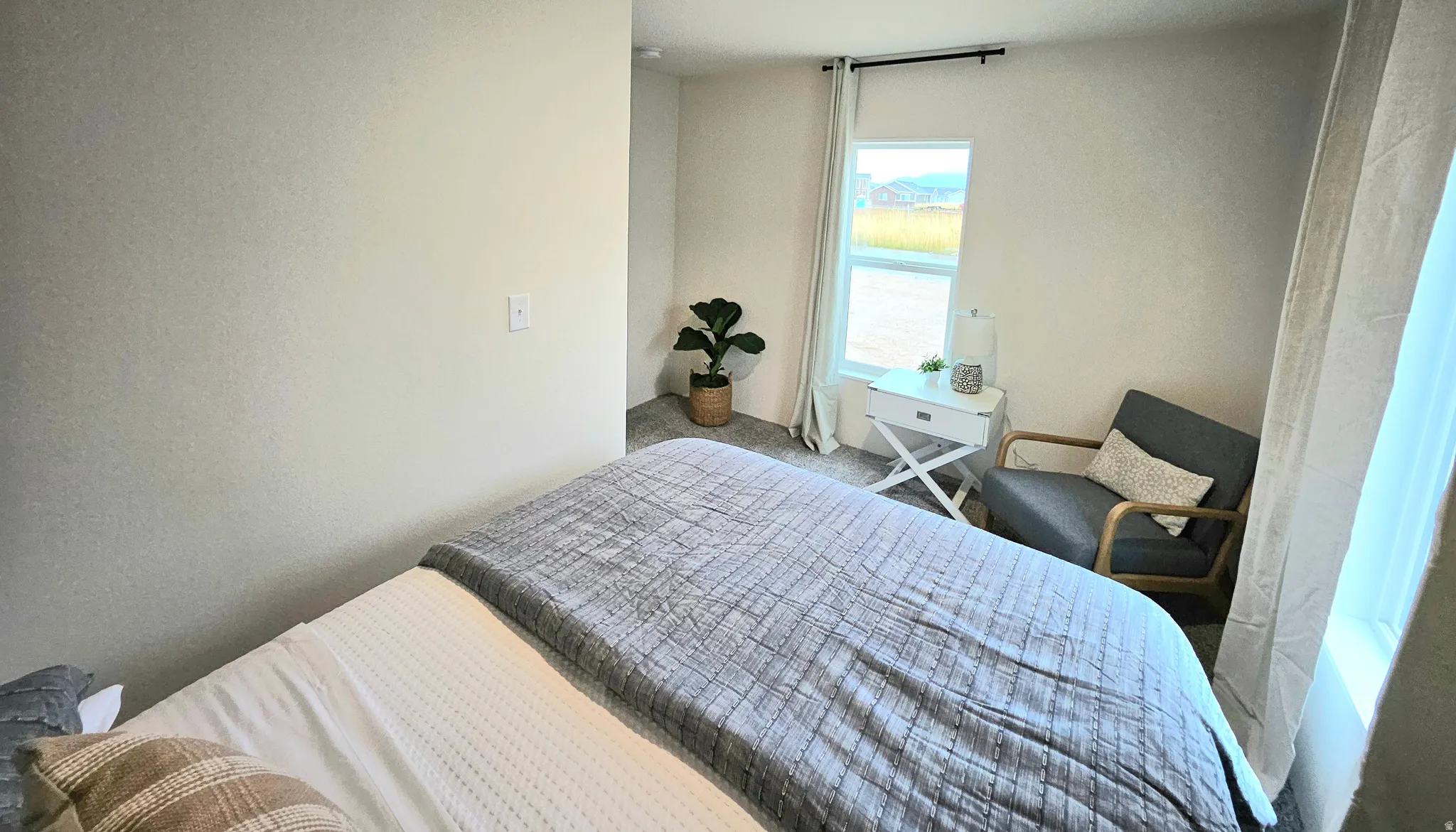 Carpeted flooring, window with curtains, and neutral wall tones