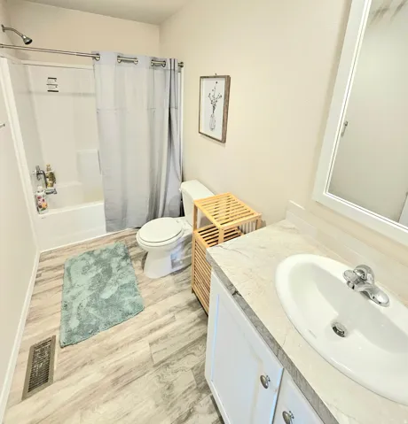 Bathroom featuring a white vanity with a built-in sink, chrome fixtures, and a white framed mirror
