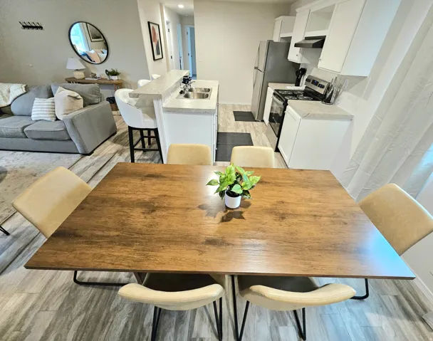 Updated kitchen with stainless steel appliances, white cabinetry, and a breakfast bar
