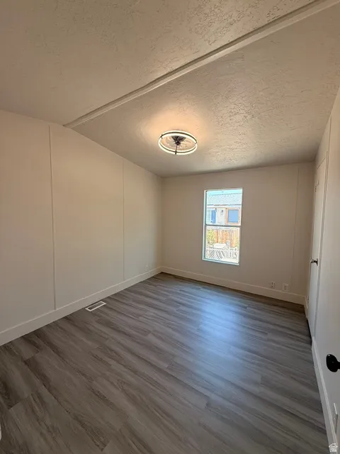 Wood-finish flooring, white baseboards, and a contemporary ceiling light fixture