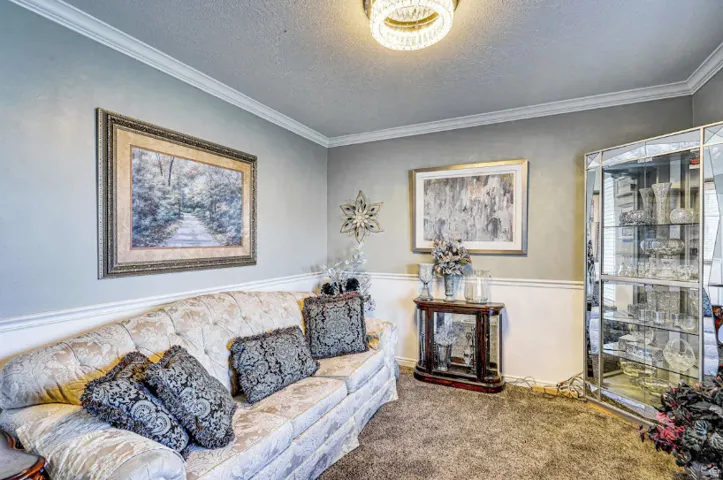 Elegant sitting room featuring crown molding, recessed ceiling lighting, and neutral wall finishes