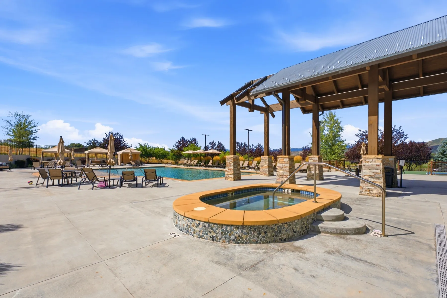 Outdoor spa with stone-finish siding and concrete steps