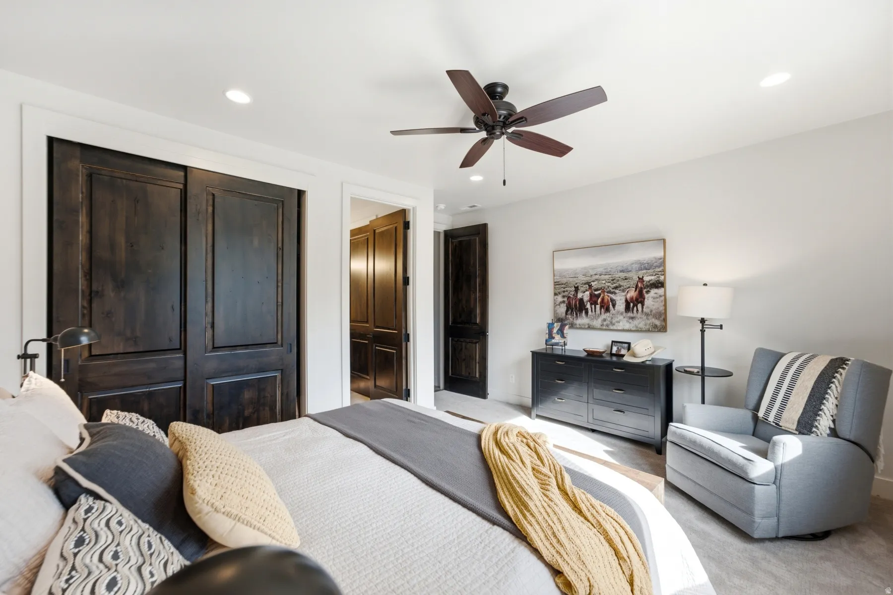 Recessed lighting, wood-finish ceiling fan, dark wood-finish paneled doors, and light-toned wall finishes