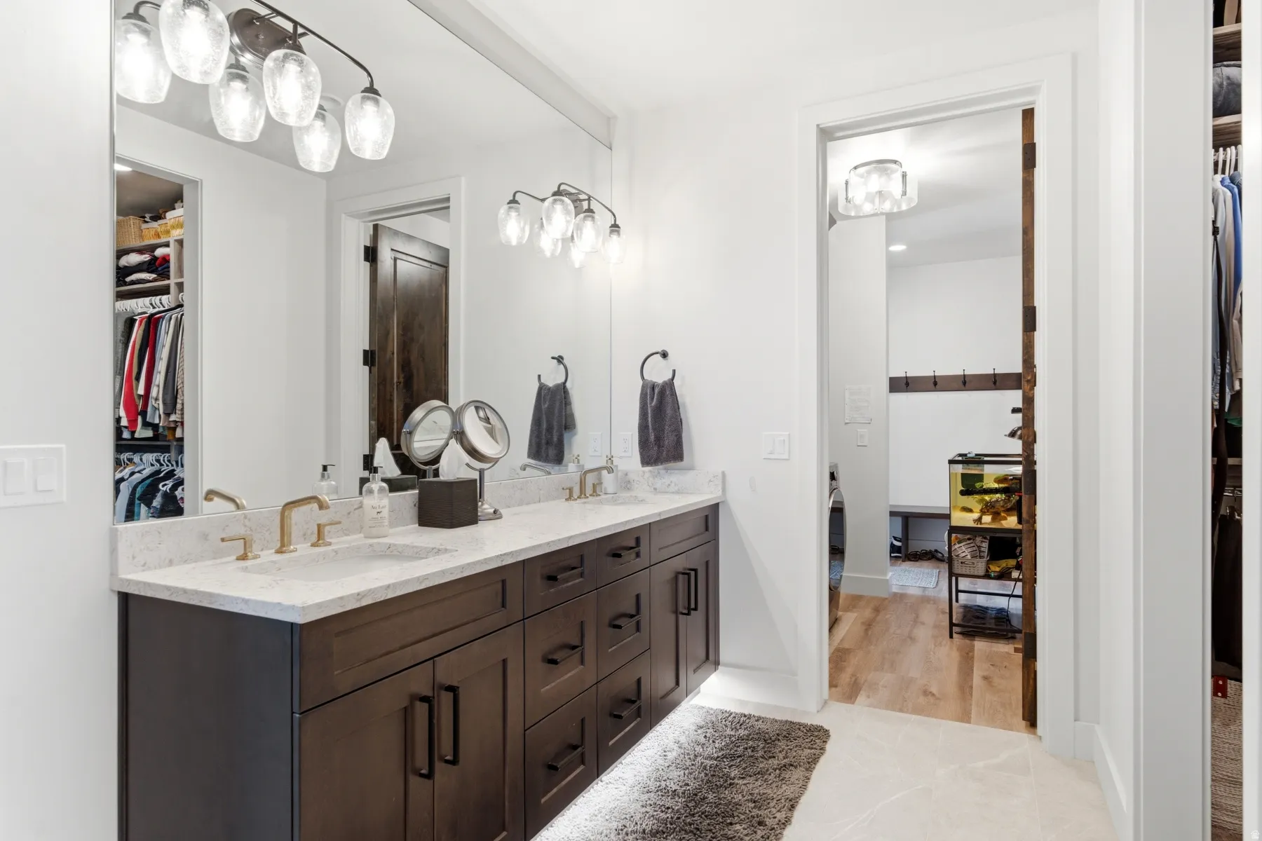 Double vanity with undermount sinks, light-toned countertop, and gold-finish fixtures