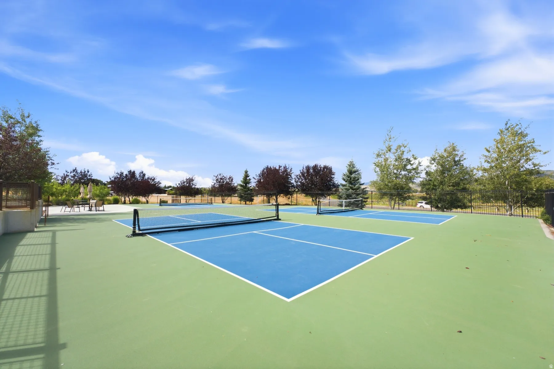 Dual outdoor sport courts with blue and green surfacing