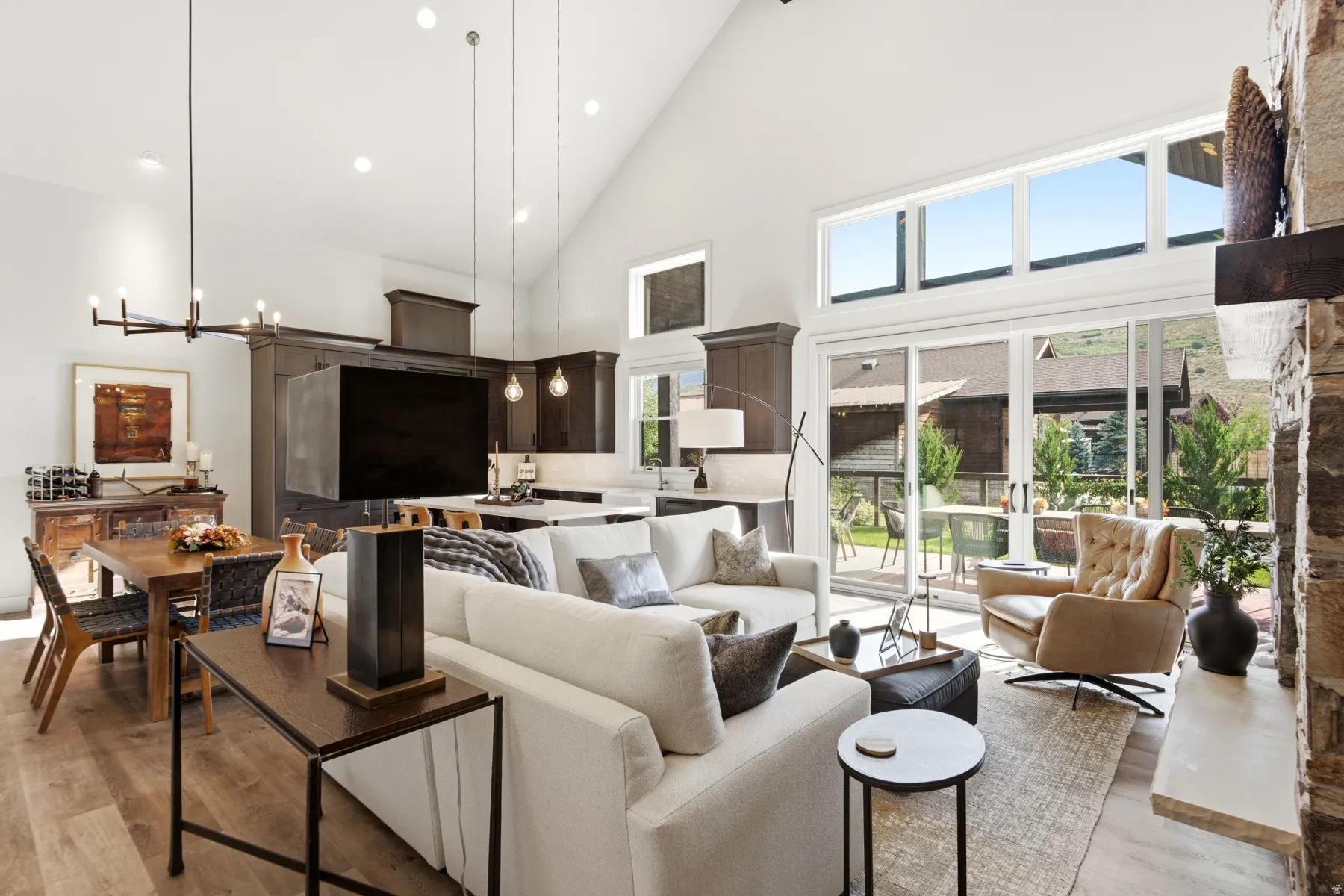 Soaring vaulted ceilings, wood-finish flooring, and a stone-clad fireplace