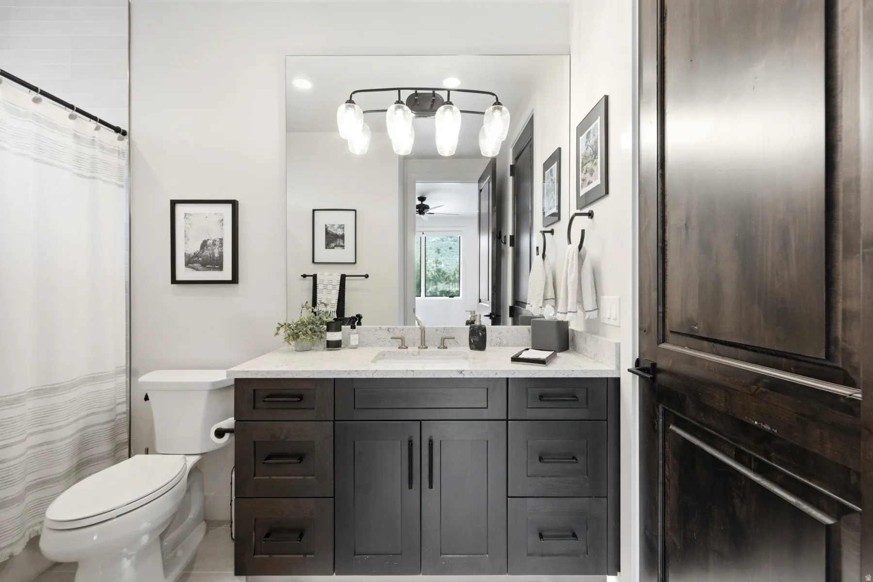 Dark wood-finish vanity with drawer and cabinet storage, light-toned countertop, and integrated sink