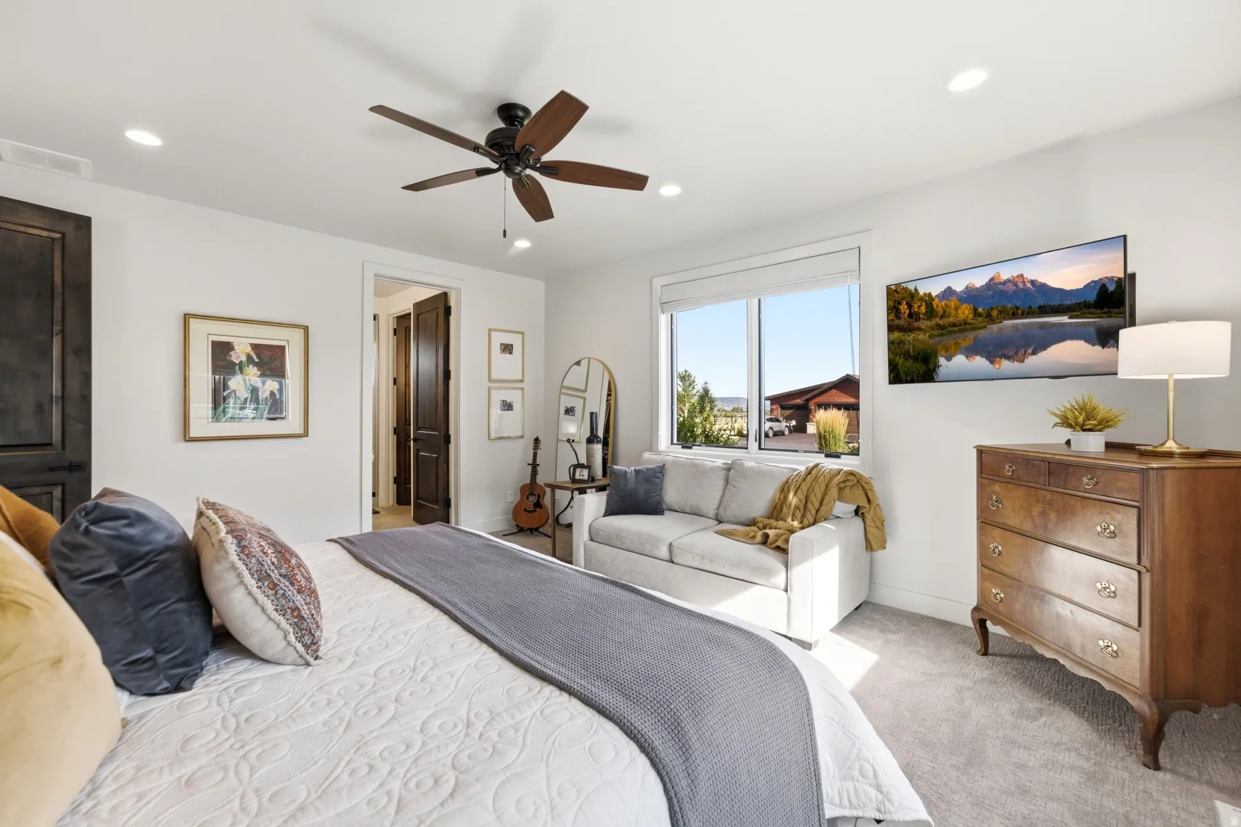 Recessed lighting, wood-finish ceiling fan, dark wood-finish interior doors, carpeted flooring, and a large window with white trim
